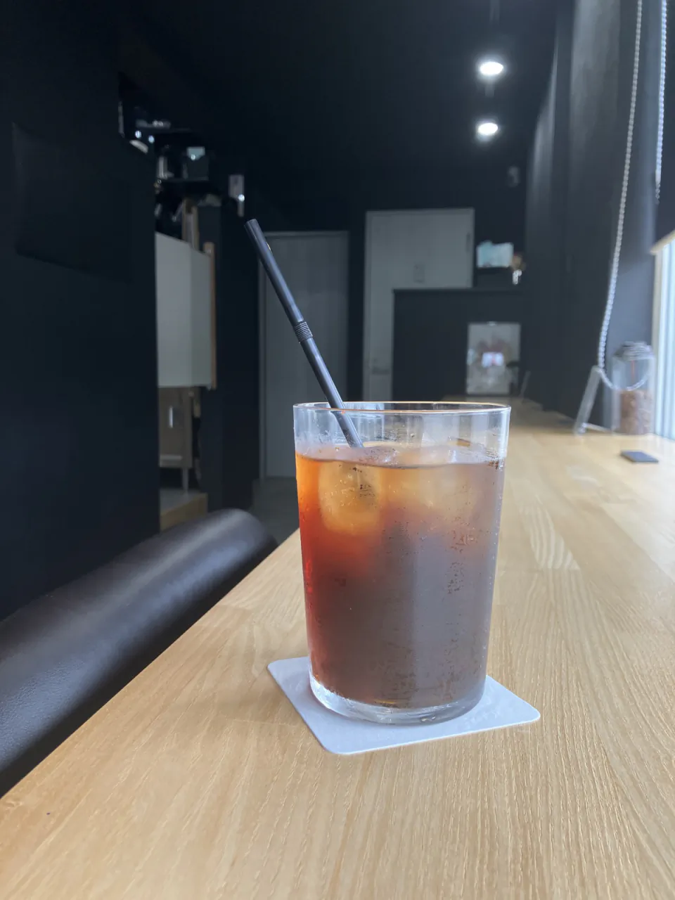木のカウンターに置かれた一杯のアイスコーヒー